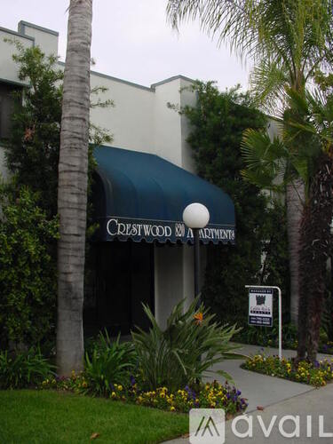 A sign for Crestwood Apartments is displayed in front of a building.