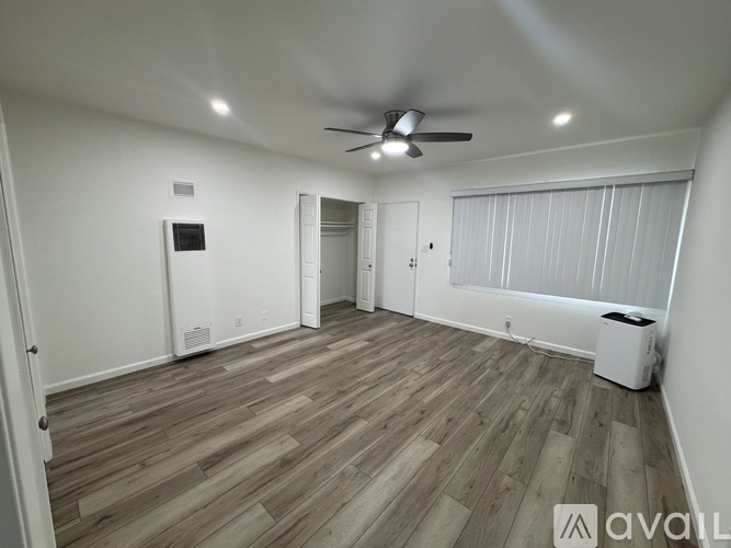 A room with wooden flooring and a ceiling fan.