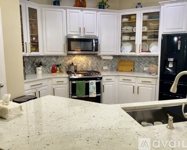 A kitchen with white cabinets and a granite countertop.