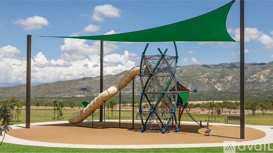 A playground with a green slide and a metal structure.