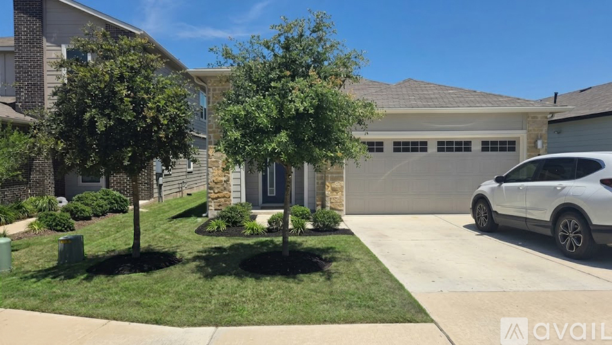 A white car is parked in front of a house.