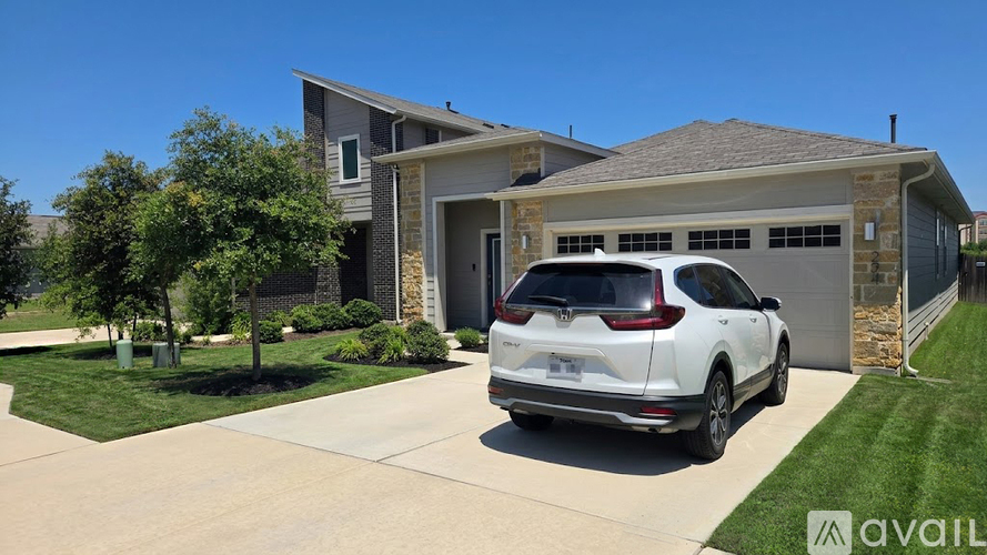 A white SUV is parked in front of a house with a garage.