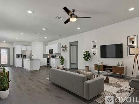 A modern living room with a grey sofa and a television on the wall.