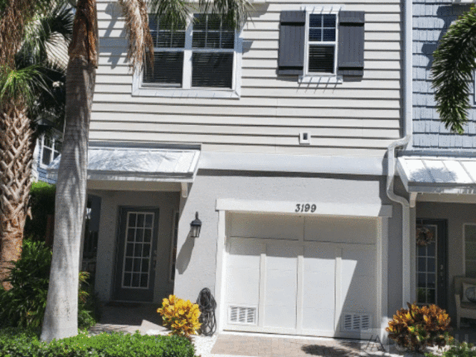 A house numbered 3129 with a white garage door.