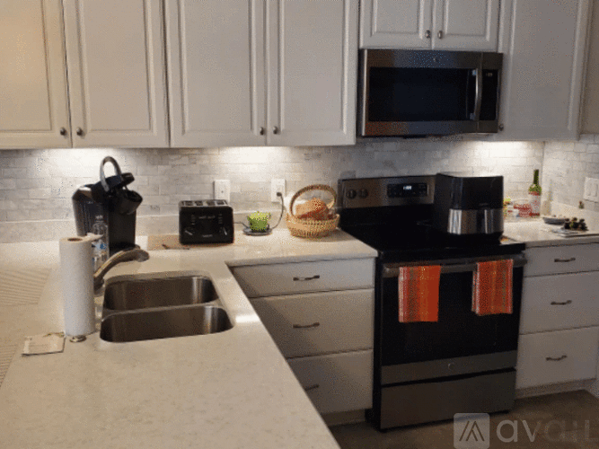 A kitchen with white cabinets and a black stove top.