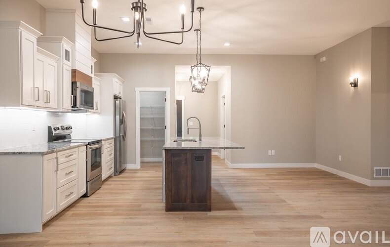 A modern kitchen with wooden floors and a large island.