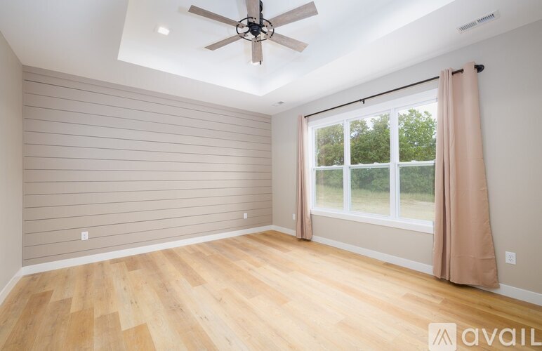 A room with wooden flooring and a ceiling fan.
