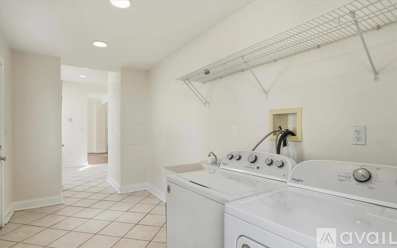 A white kitchen with a washer and dryer.