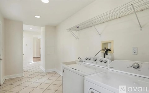A white kitchen with a washer and dryer.
