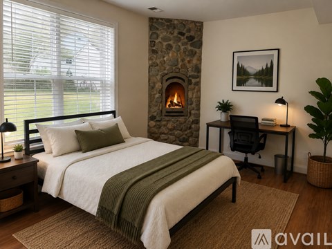 A bedroom with a stone fireplace and a bed with a green blanket.
