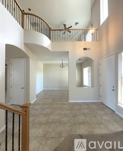 A spacious living room with a balcony and a ceiling fan.