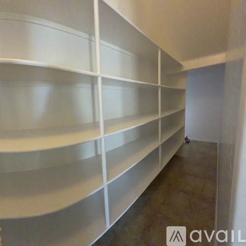 A long white shelving unit with no items on it.