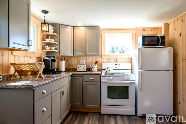 A kitchen with wooden walls and a white fridge.