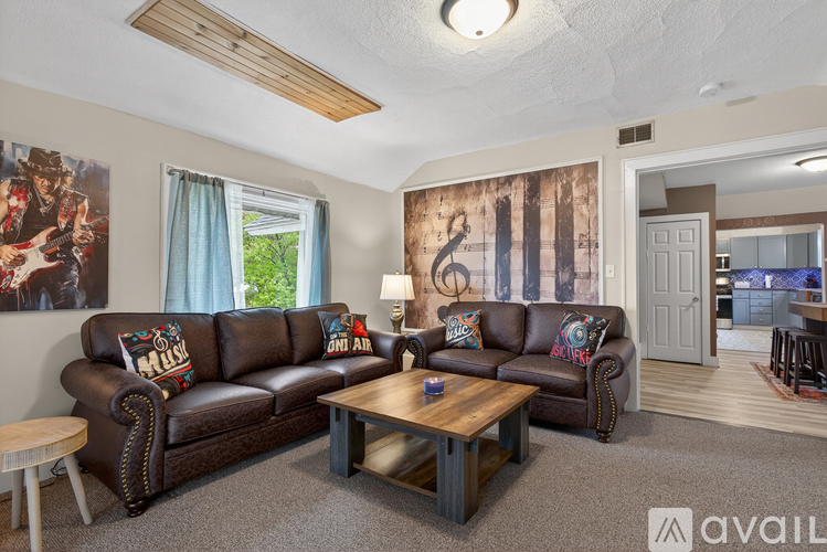 A living room with a brown leather couch and a wooden coffee table.