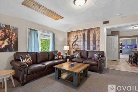 A living room with a brown leather couch and a wooden coffee table.