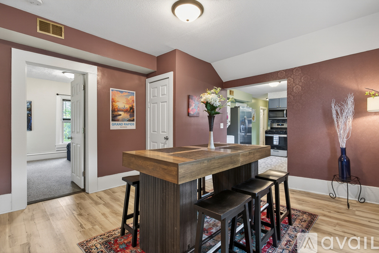 A kitchen with a wooden table and bar stools.