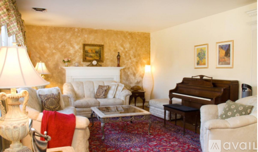 A living room with a piano and a fireplace.