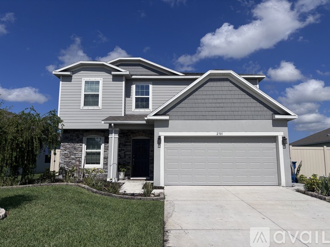 A two-story house with a garage is available for sale.