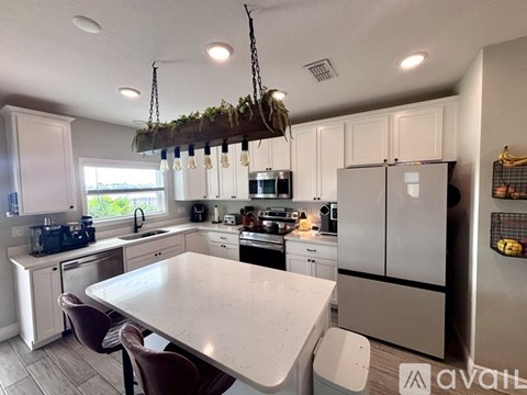 A kitchen with a table and chairs and a hanging plant.