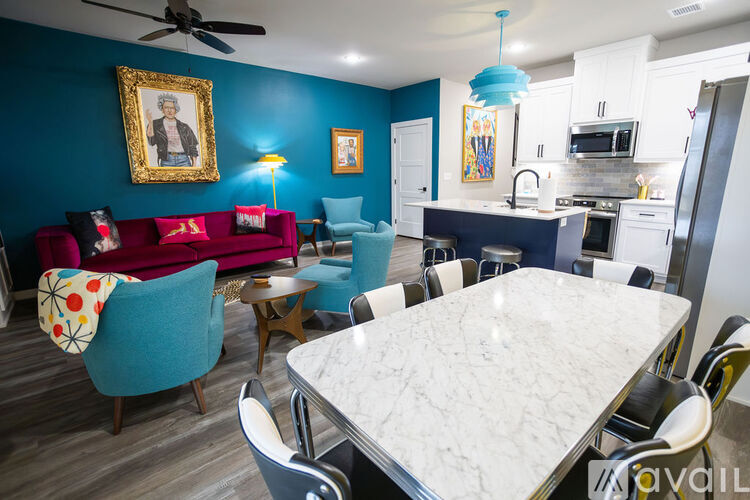 A living room with a red couch and a dining table.