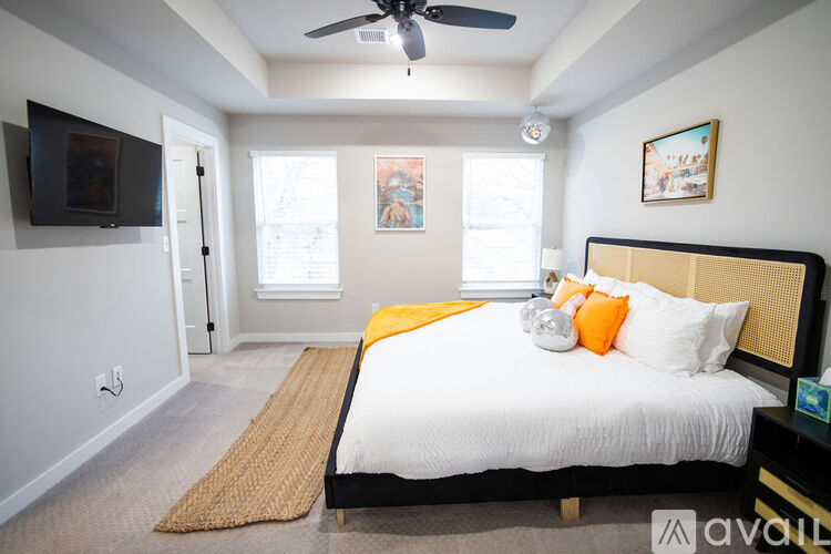 A bedroom with a bed, a ceiling fan, and a television.
