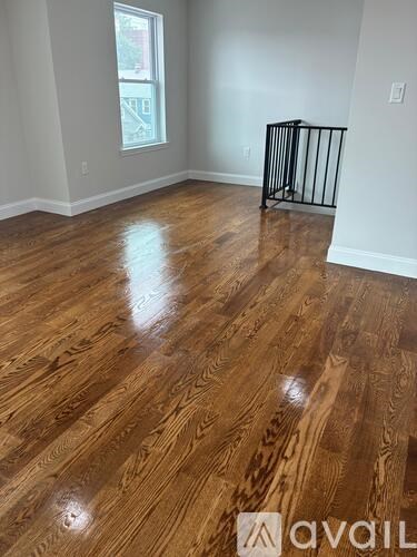 A room with wooden flooring and a window.