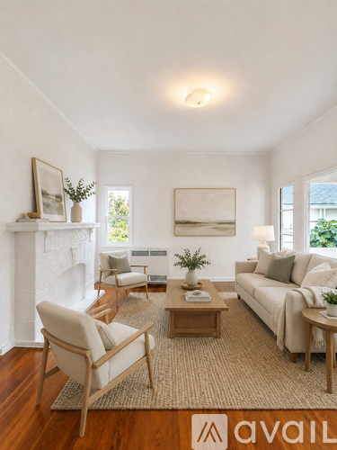 A living room with a white fireplace, a couch, a chair, a coffee table, and a painting on the wall.
