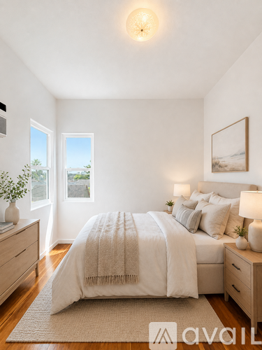 A bedroom with a large bed, a window with a view, and a painting on the wall.