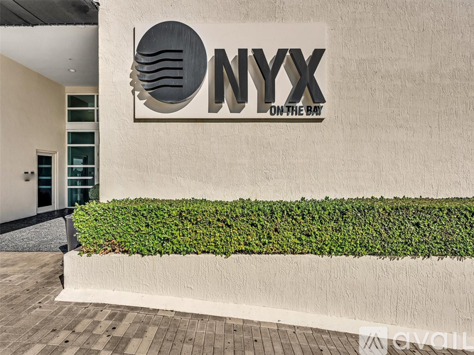 A white wall with a sign that says NYX on it.