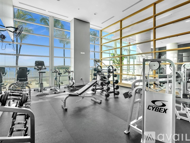 A gym with a variety of equipment including dumbbells, weight machines, and a bench press.