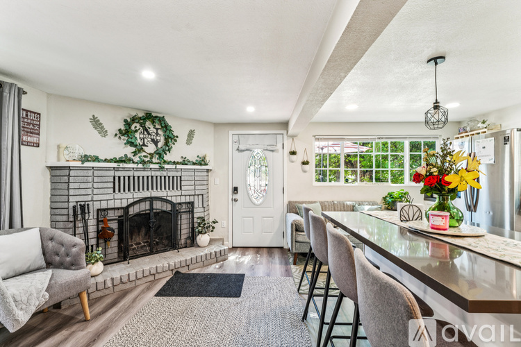 A living room with a fireplace and a dining table.