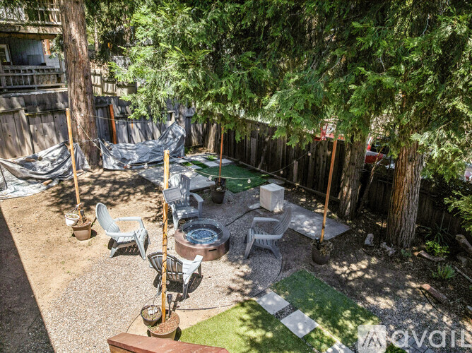A backyard with a hot tub and patio furniture.