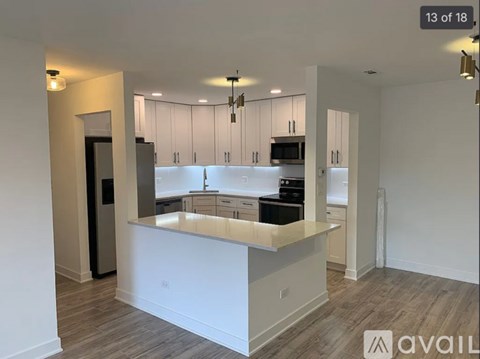 A modern kitchen with white cabinets and a central island.