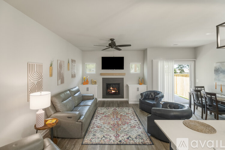 A living room with a grey couch, a fireplace, and a television.