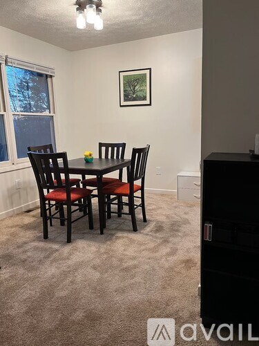 A dining room with a table and chairs.