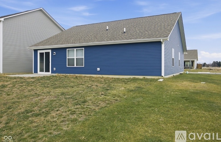A blue house with a grey roof and a white door.