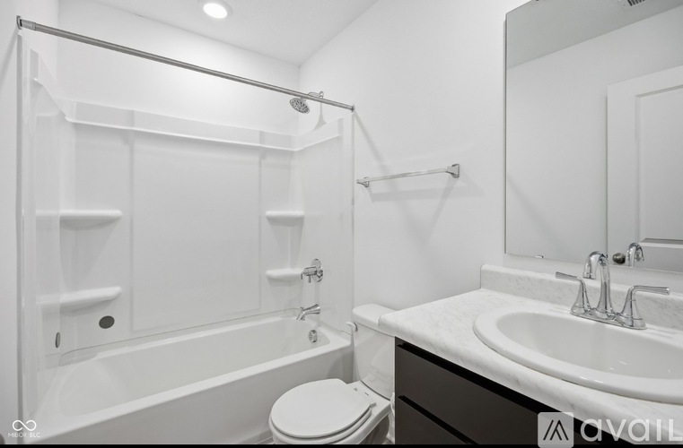 A white bathroom with a toilet, sink, and bathtub.