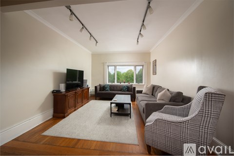 A living room with a grey sofa and a wooden floor.