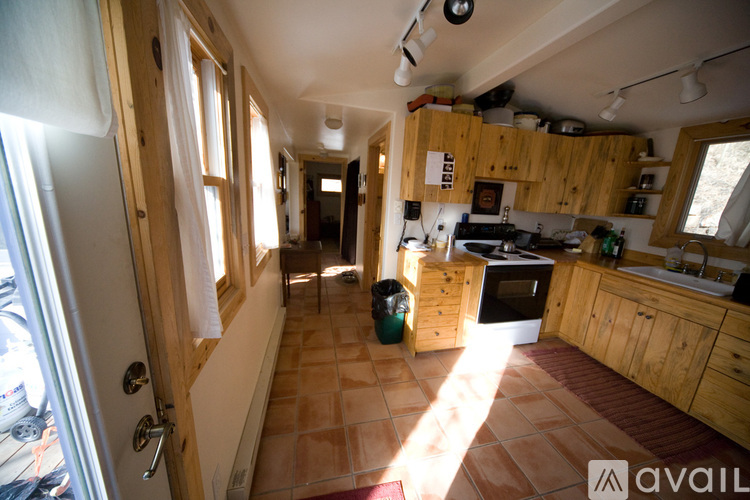 A kitchen with wooden cabinets and a tiled floor.