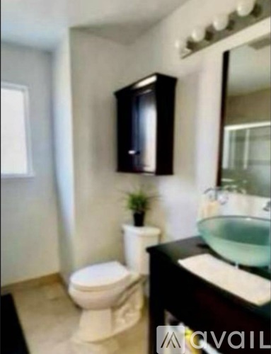 A bathroom with a toilet, sink, and mirror.