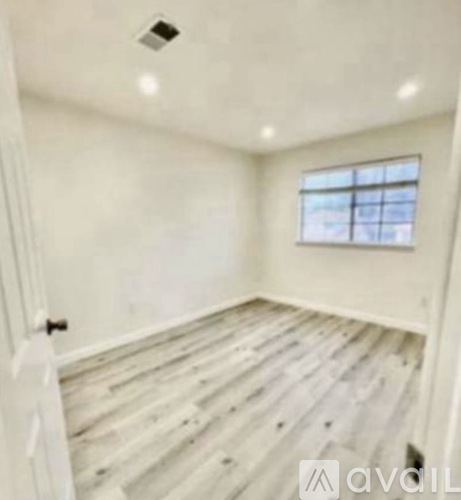 A room with wooden flooring and a window.