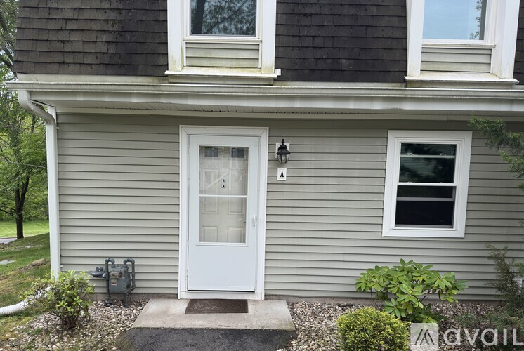 A house with a grey siding and a white door.