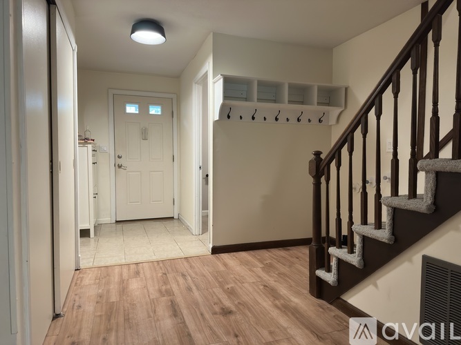 A hallway with a staircase and a white door.