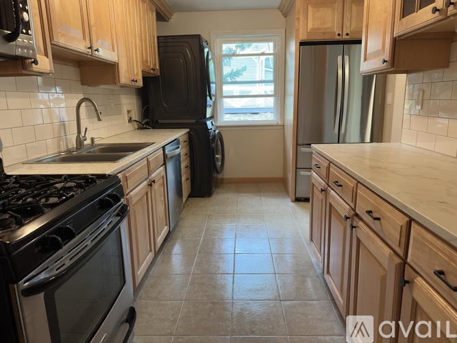 A kitchen with wooden cabinets and black appliances.