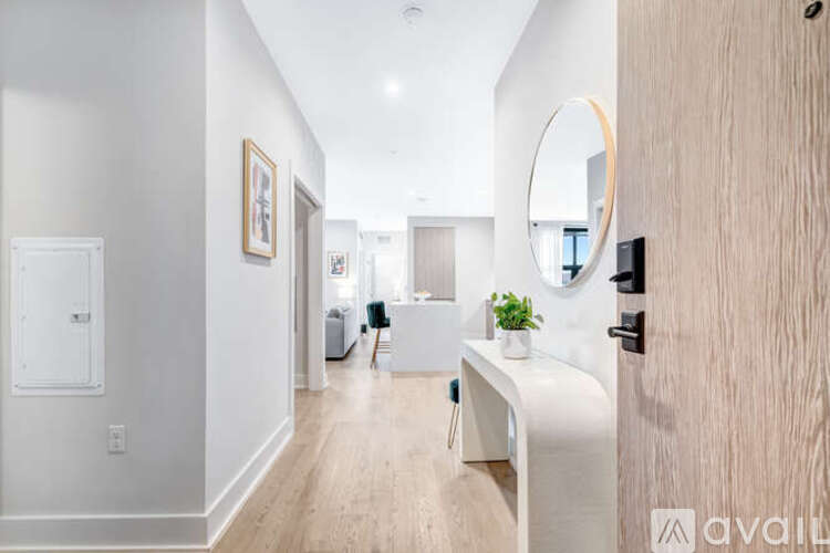 A hallway with a white bench and a round mirror on the wall.