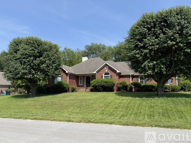 A house with a lawn and trees in front of it.