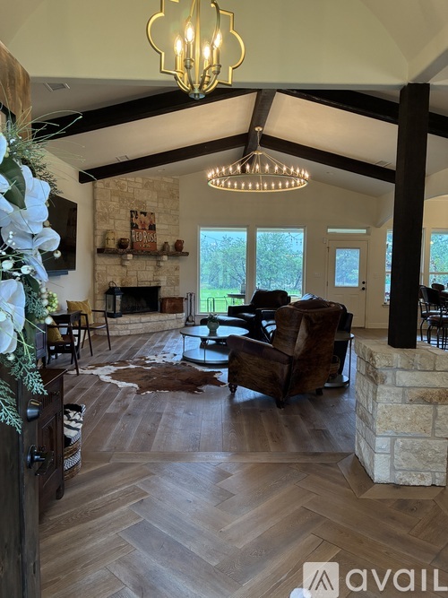 A living room with a stone fireplace and a cowhide rug.
