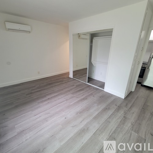 A room with a white door and a wooden floor.