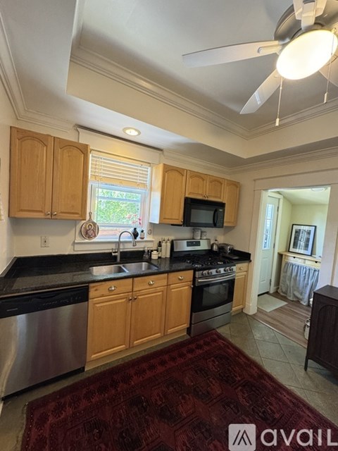 A kitchen with wooden cabinets and a black countertop.
