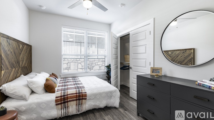 A bedroom with a bed, dresser, and mirror.